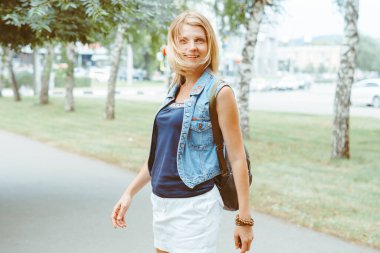 Yazın parkta yürüyen güzel genç bir kadın.