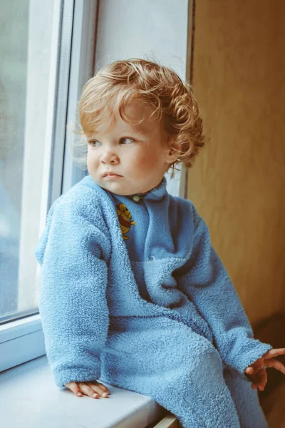 Маленький Серьезный Мальчик Сидит Окна — стоковое фото