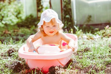 Mutlu bebek bahçede banyo yapıyor.