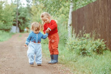 kız ve erkek kardeş caddede yürüyorlar küçük bir köyde evlerin arasında