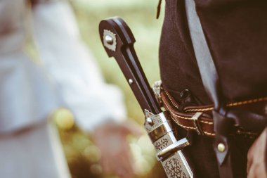 Kazağın kemerindeki kılıç kınında kılıcın kabzası.