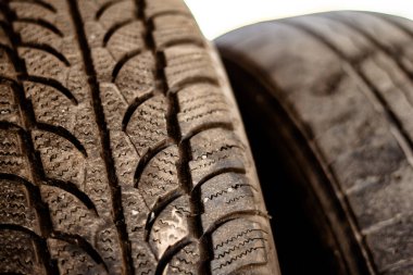 Kurulum atölyesindeki metal bir rafta duran eski araba lastikleri.