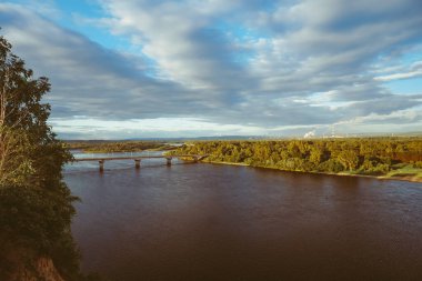 Bir adam uçurumun yakınındaki bir kayanın üzerinde duruyor. Güzel kümülonimbus bulutları ve sarp kayalıkları olan yaz manzarası