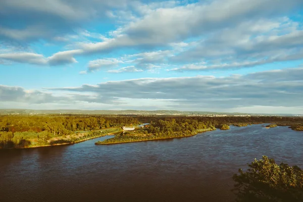 Bir adam uçurumun yakınındaki bir kayanın üzerinde duruyor. Güzel kümülonimbus bulutları ve sarp kayalıkları olan yaz manzarası