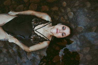 Küvetteki kadın, suyun üstünde sadece yüzü olan güzel, sakin bir ifade.