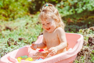 Mutlu bebek bahçede banyo yapıyor.
