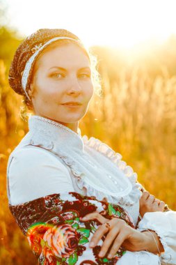 Gün batımında ulusal kostümlü bir kız.