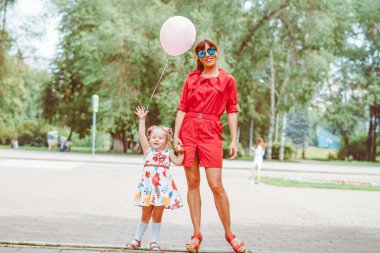 Mutlu anne ve kız doğaya gülümsüyor.