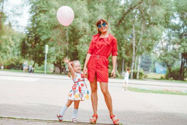 Mutlu anne ve kız doğaya gülümsüyor.