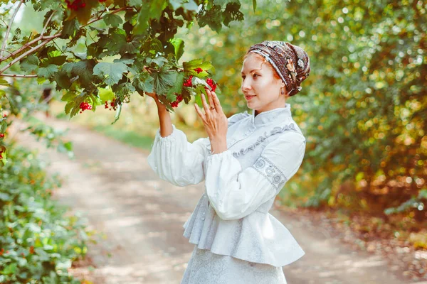Antika elbiseli güzel bir kız bir ağacın yanında duruyor.