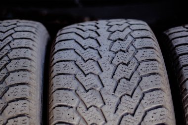 Eski araba lastikleri metal bir rafta duruyor.