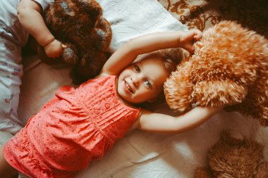 Çocuklar yan yana yere yatar, ablalar oynar.