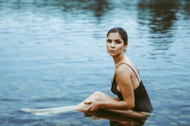 Seksi esmer, çekici ve güzel göğüsleri olan bir kadın.