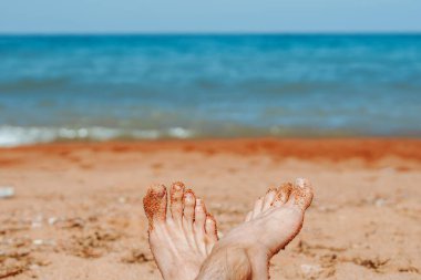 Sahilde bronzlaşmak. Kadının Çıplak Ayakları Deniz Arkaplanı