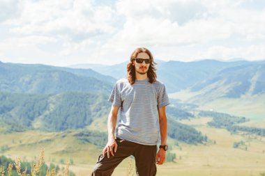 Adam tepenin zirvesine bakıyor. Adam dağın tepesinde duruyor ve Kootenay Vadisi, Creston, British Columbia, Kanada manzarasının tadını çıkarıyor.