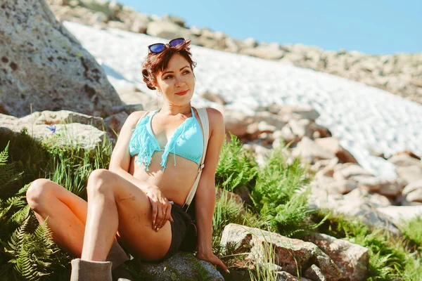 Mayolu güzel bir kız dağların arasında zarif bir şekilde oturuyor.