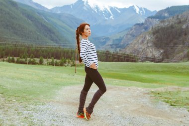 Dağların arkasında poz veren güzel bir kız.