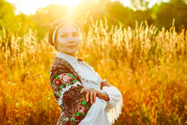 Ein Mädchen im Nationalkostüm bei Sonnenuntergang — Stockfoto