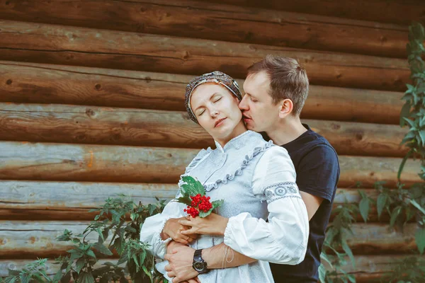 A guy and a girl are standing in an embrace on a field of grass — Fotografia de Stock