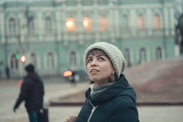 Una chica en un sombrero de invierno pasea por la ciudad — Foto de Stock