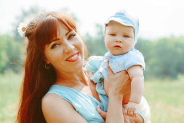 Genç bir anne bebeği kollarında kaldırdı