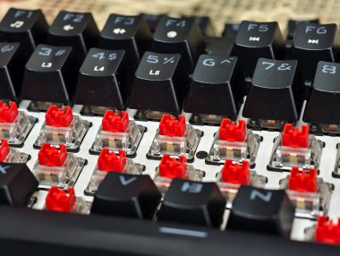 Siyah tuşlu kırmızı mekanik klavye anahtarlarının yakın çekim, makro perspektifi beyaz bir plakaya kısmen yeniden yüklendi.