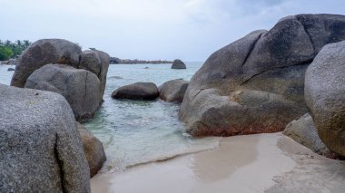 Siangau Sahili 'nin beyaz kumlu sahilinde, sakin denize bakan iki dev granit kayadan oluşan doğal bir geçit.