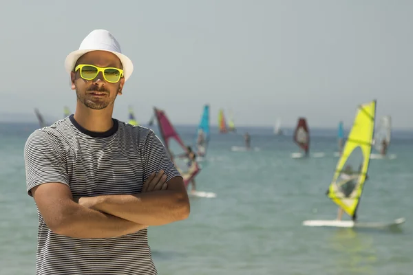 Turistické chlap portrét a windsurfing v pozadí na pláži — Stock fotografie