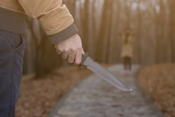 Man med kniv och rädd kvinna i parken — Stockfoto
