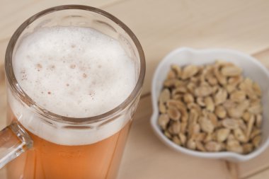 Fıçı bira ve ahşap masa üzerinde kase fıstık