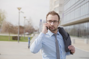 Yönetici açık havada akıllı telefonda konuşuyor   