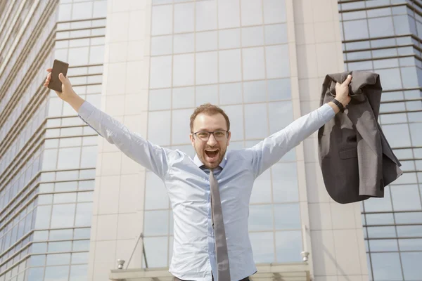 Щасливий бізнесмен святкує свій успіх перед бізнес-будівлею — стокове фото