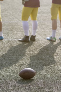 Sahada top ve Amerikan futbol oyuncuları 