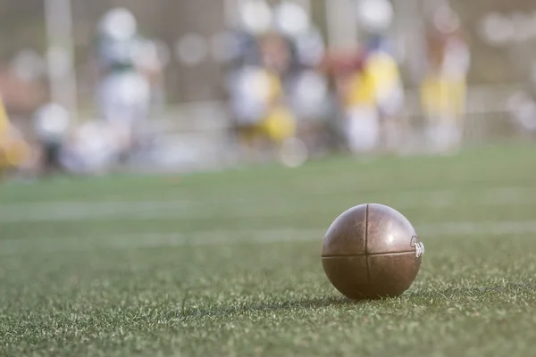 Amerikaans voetbal bal en de spelers op de achtergrond — Stockfoto