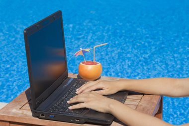 Havuz kenarındaki, laptop klavye üzerinde eller      