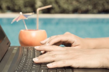 Havuz kenarındaki, laptop klavye üzerinde eller      