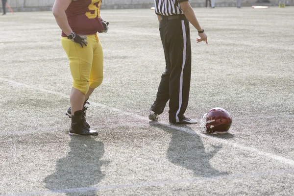 American football speler, scheidsrechter en helm op het veld — Stockfoto