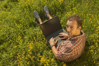 Genç adam onun laptop açık havada üzerinde çalışıyor