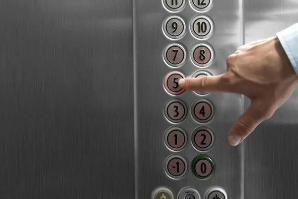 Dedo indicador pressionando o botão do quinto andar no elevador — Fotografia de Stock