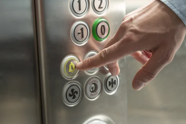 Hand att trycka på larmknappen i hissen — Stockfoto