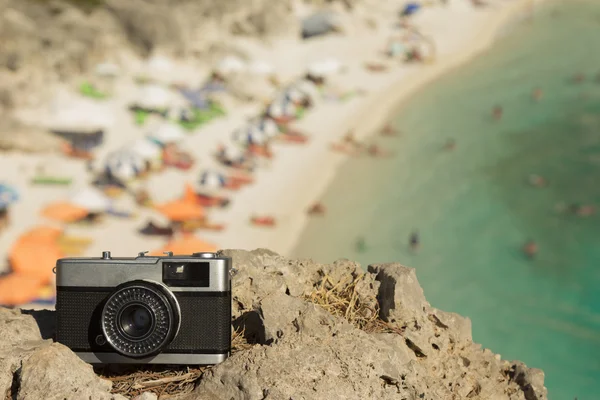 Ретро камера на скелі з красивим пляжем на фоні — стокове фото