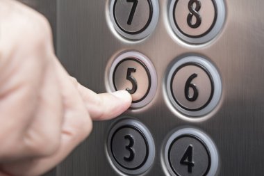 Asansörde Beşinci kat düğmesine basarak işaret parmağı