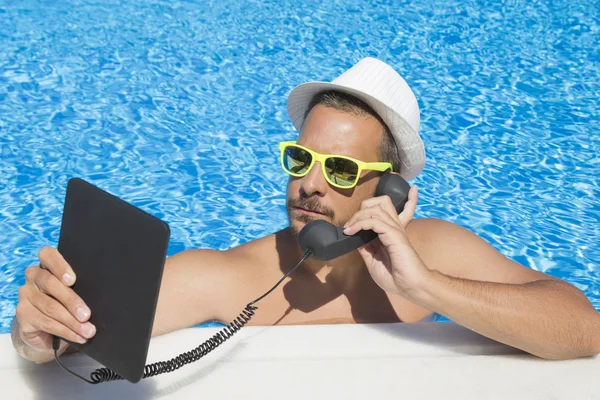 Tipo que tiene una llamada por Internet desde la piscina — Foto de Stock