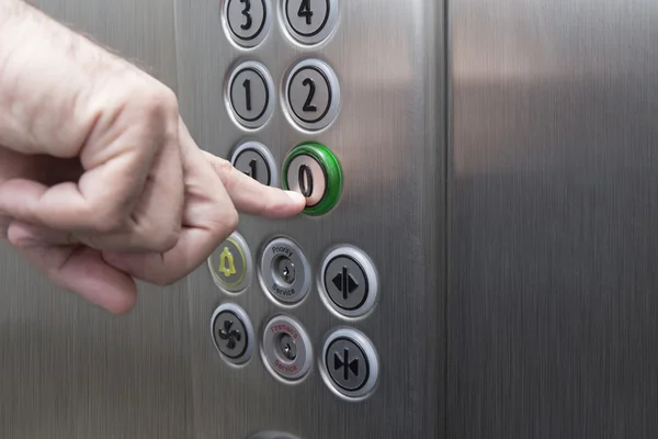 エレベーターの中でゼロの階のボタンを押すと人差し指 — ストック写真