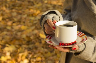 Bir fincan kahve açık havada tutan kadın 