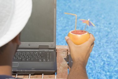 Dizüstü bilgisayarda çalışan ve yaz tatili zevk adam