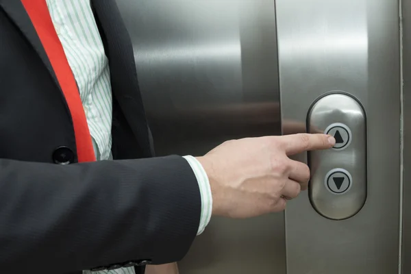 Affärsman pressning hiss upp knappen — Stockfoto