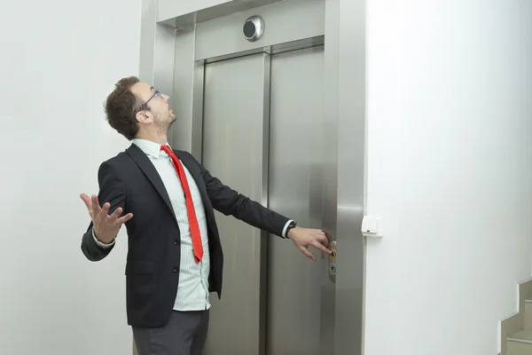 エレベーターが動作しないために、ビジネスマンは混乱しています。 — ストック写真