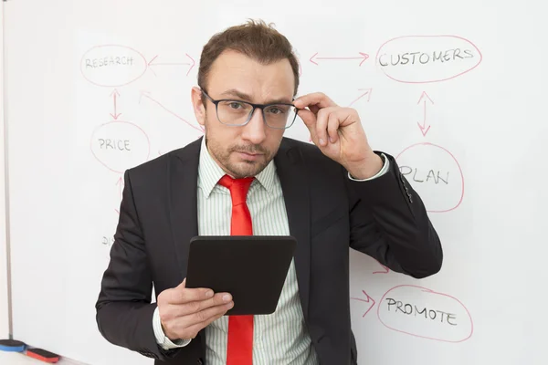 Retrato de un empresario con una tableta digital. Diagrama de flujo en el fondo . — Foto de Stock