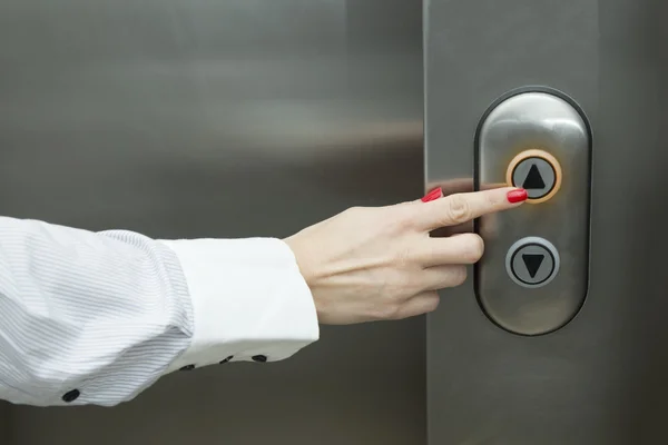 Kvinnliga handen trycka hiss upp knappen — Stockfoto